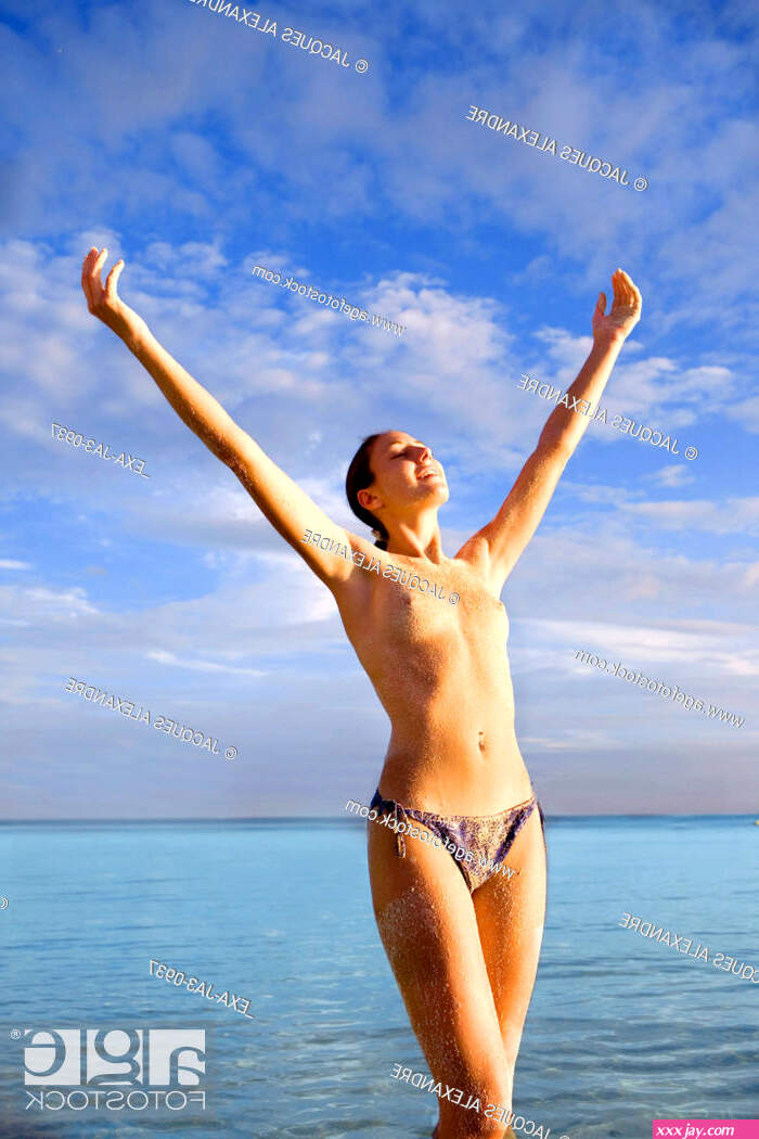 Semi-nude woman with arms raised at beach Stock Photo Picture And Rights Managed Image. Pic. EXA-JA3-0937